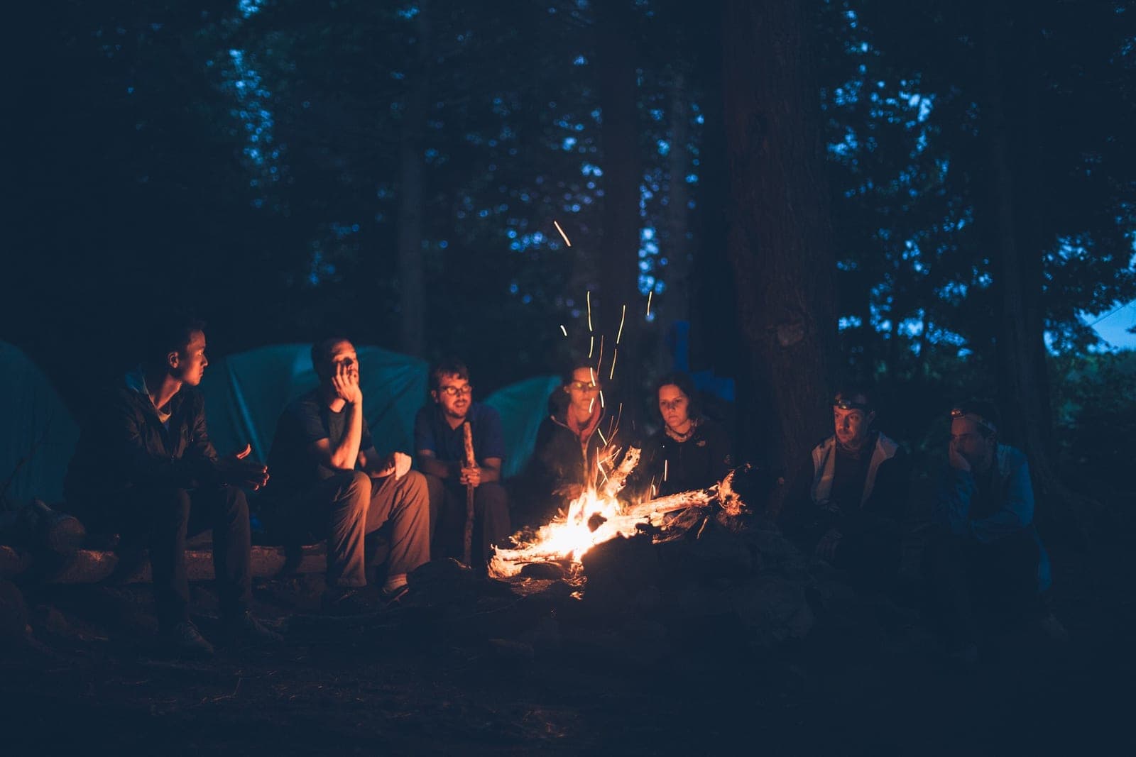 Gruppe sitzt abends am Lagerfeuer