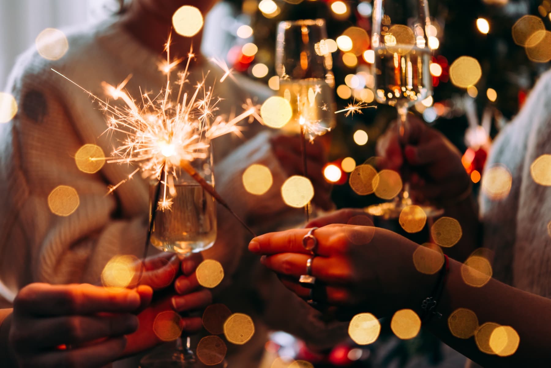 Anstoßen mit Wunderkerzen am Weihnachtsbaum